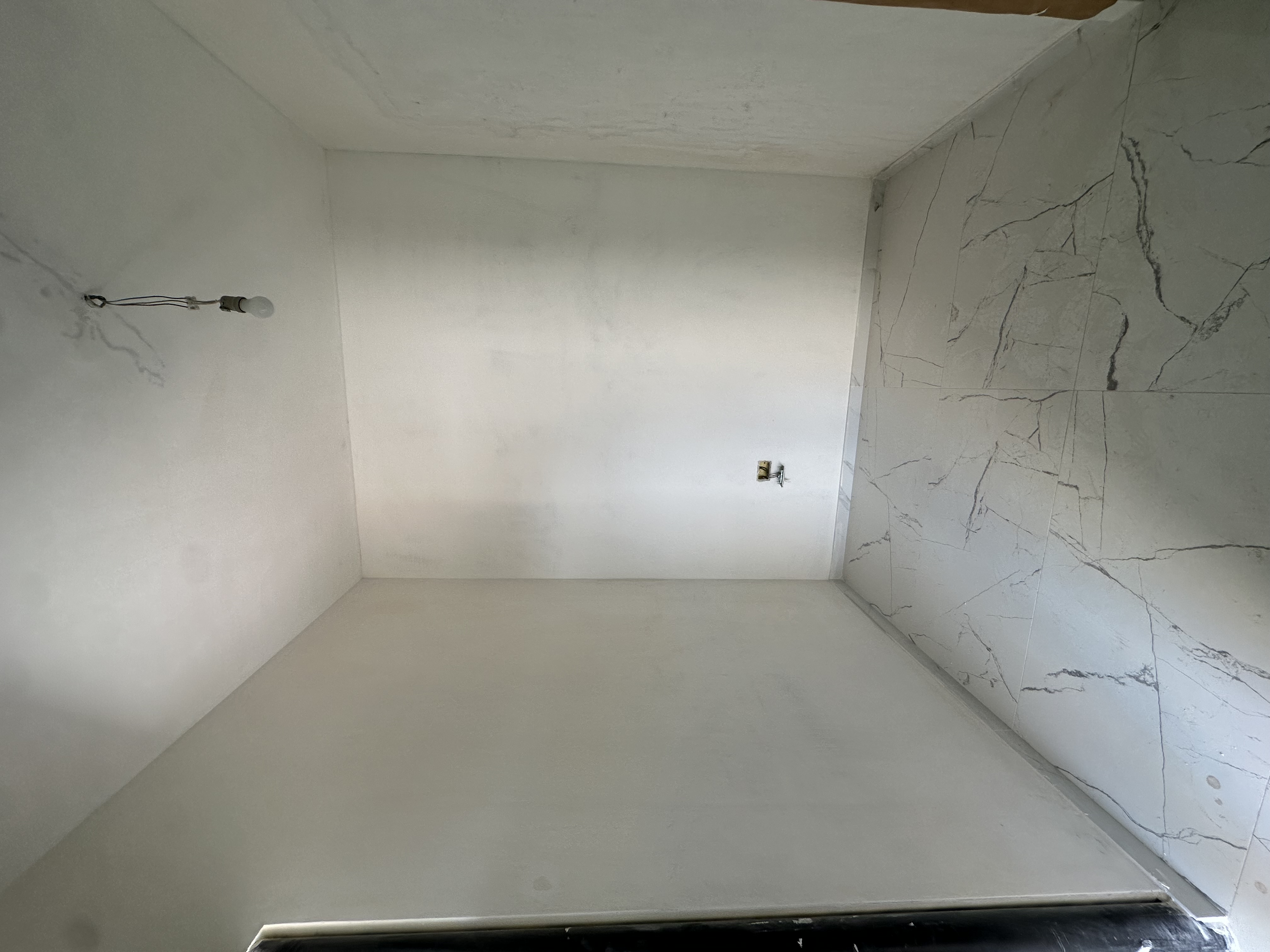 Foto del cantiere prima dei lavori: stanza vuota con marmo posato